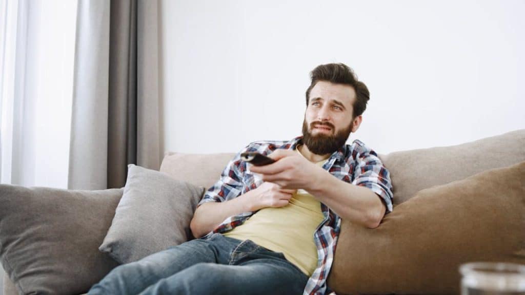 Man lounging on the couch while watching TV