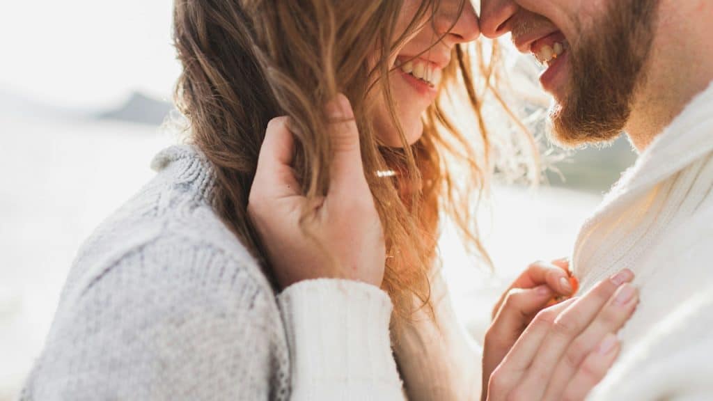 A couple smiling and about to kiss.