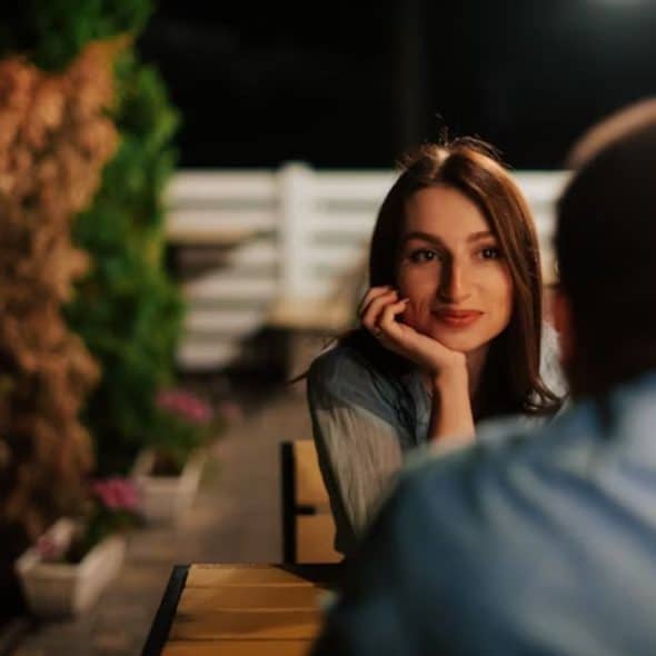 Woman sitting quietly beside her partner, looking thoughtful