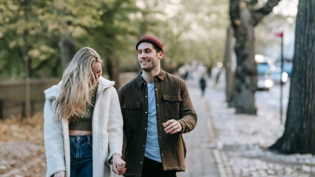Couple walking hand in hand through a park