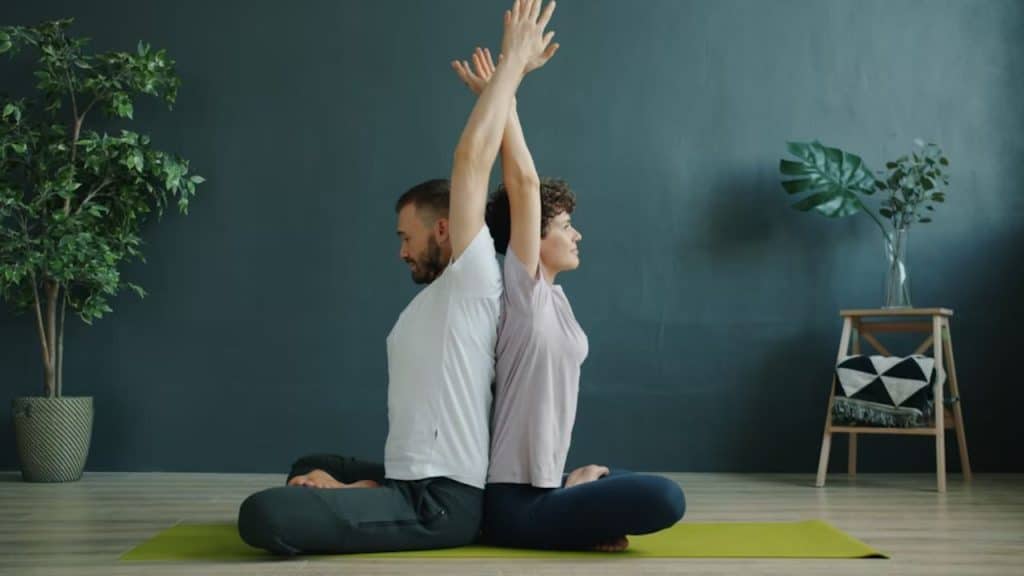 A couple learning yoga together at home