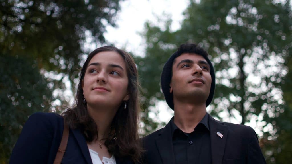 A young man and a woman standing outdoors.