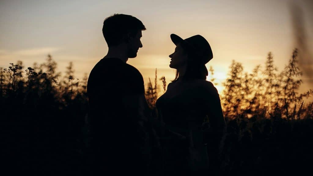 A couple looking at each other during sunset