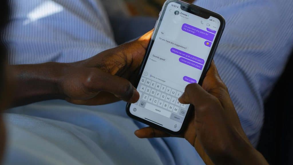 A person holding a smartphone while typing a message.