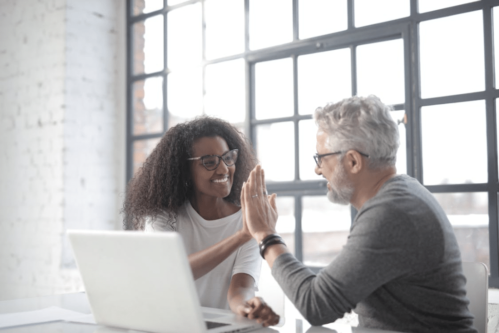 Happy man giving high five to a younger woman