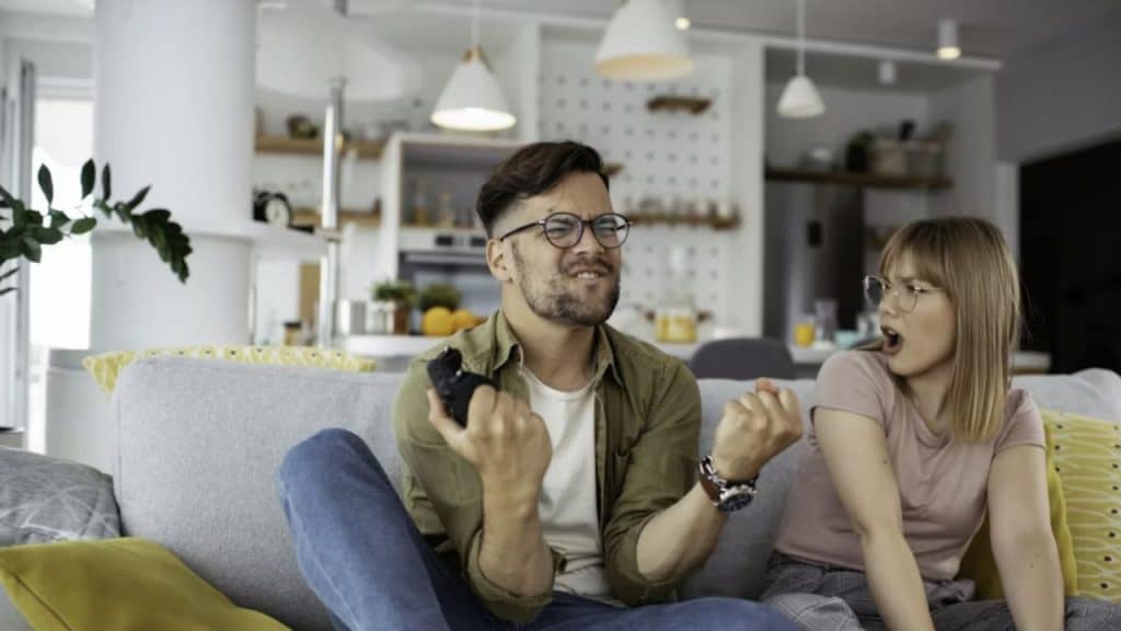 Man smiling about an achievement as his partner reacts coldly