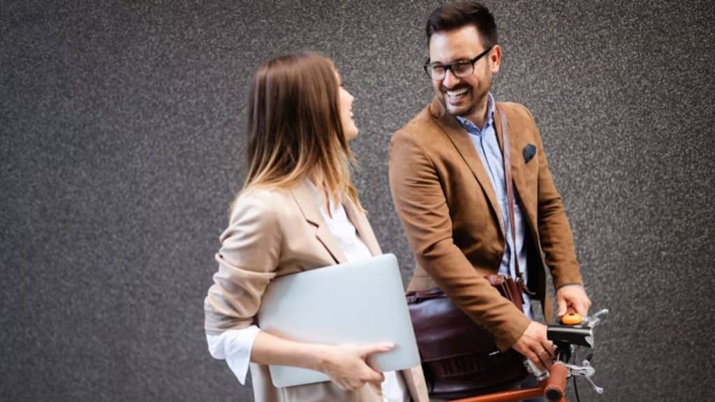 A man and a woman smiling confidently while walking
