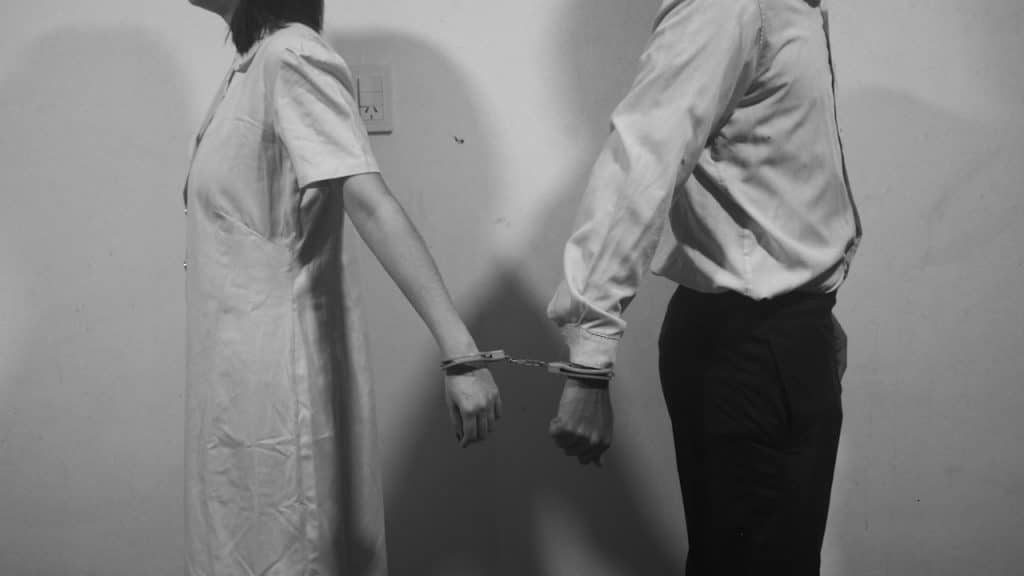 A couple with handcuffs on.