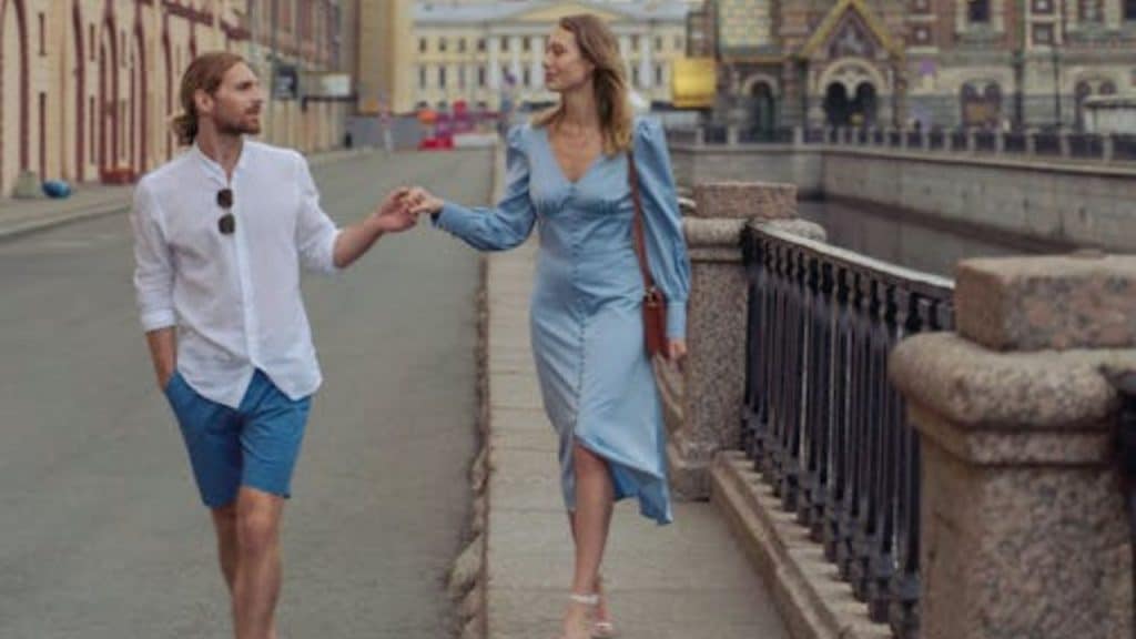 A couple smiling at each other while walking together