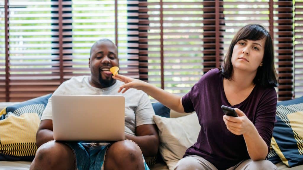 A man and woman sitting on a sofa.