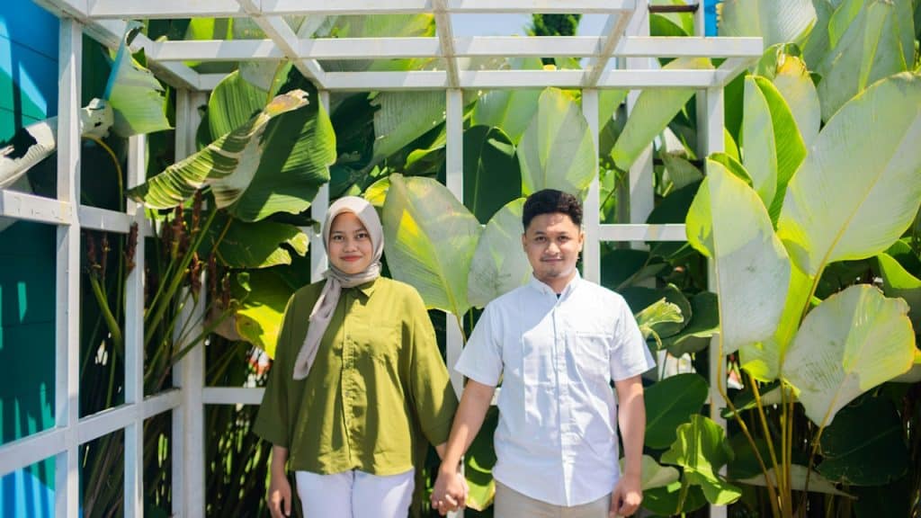 A man and woman standing in front of a greenhouse.