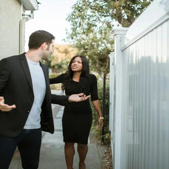 A couple arguing outside their home