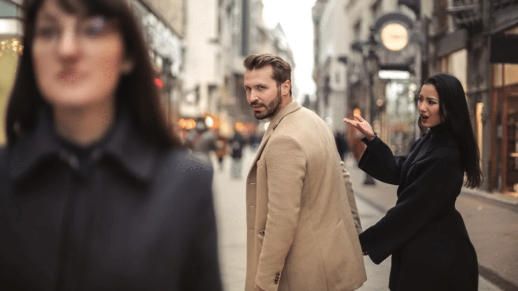 A man looking at another woman while with his girlfriend