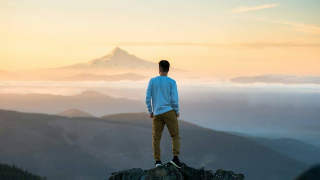 A man standing on the top of a mountain.