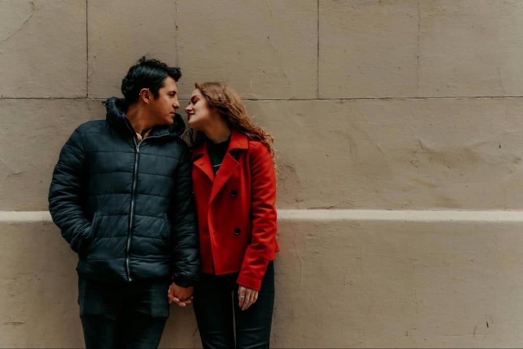A man and woman leaning at the wall