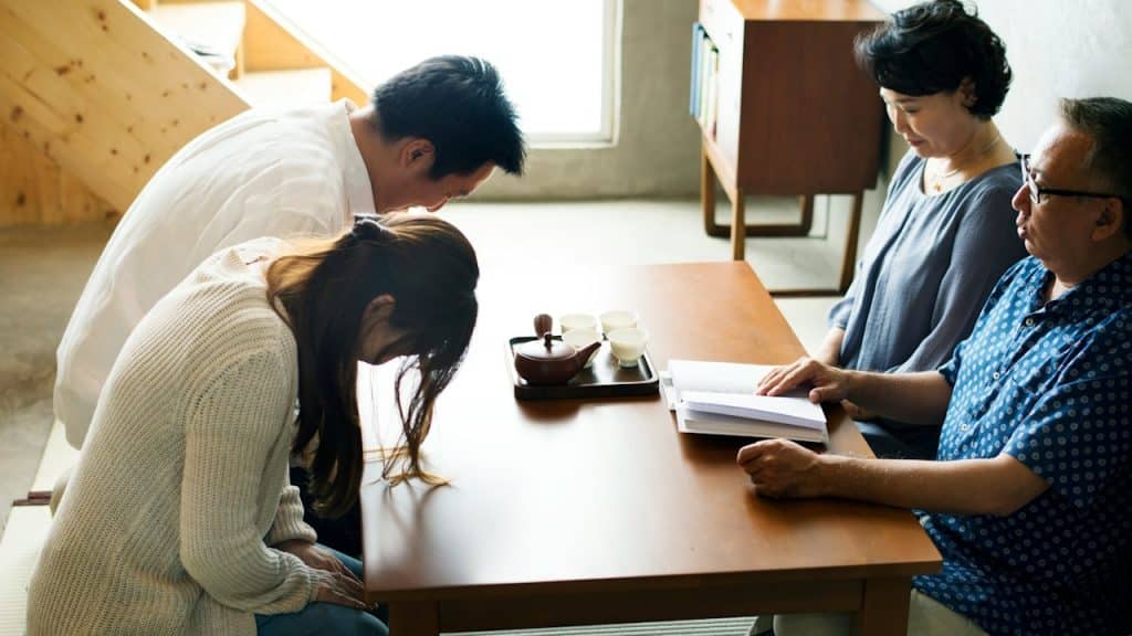 Japanese family greeting bowing in front of parents.