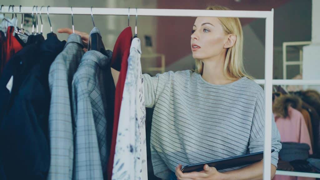 The woman is choosing clothes in a boutique.