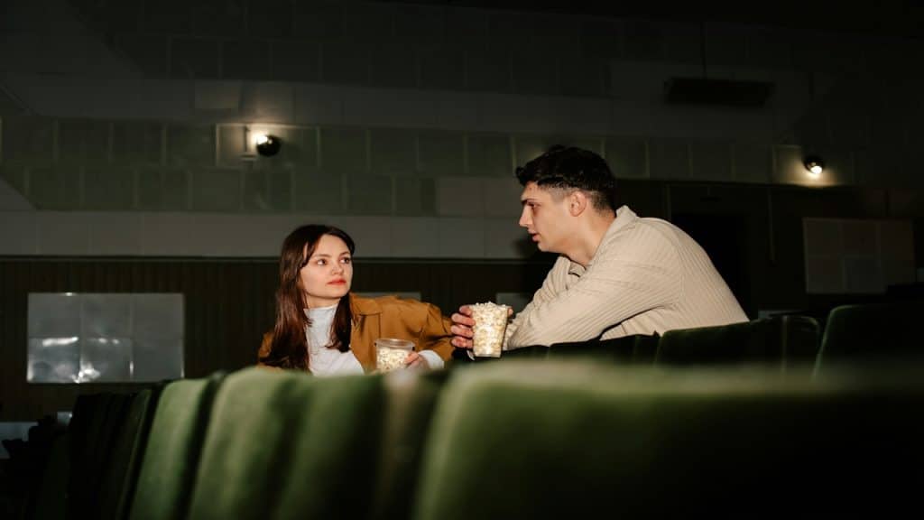 A bored couple sitting in a cinema.
