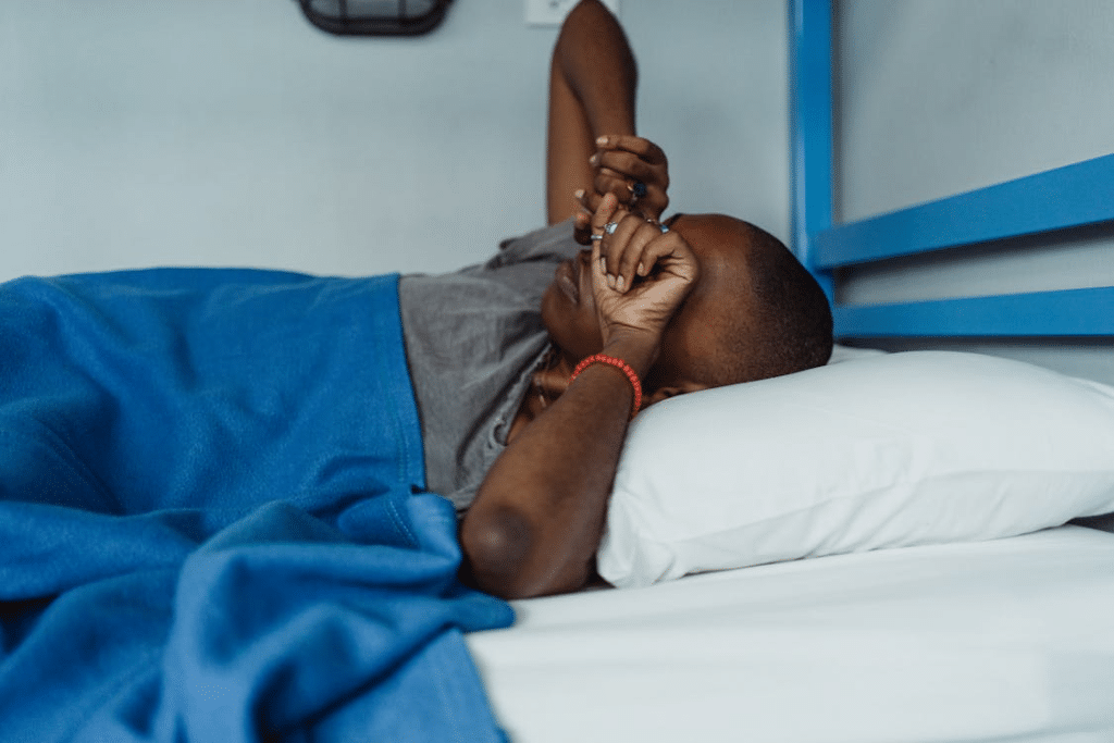 Woman in Gray T-Shirt Waking Up in Bed with Blue Blanket