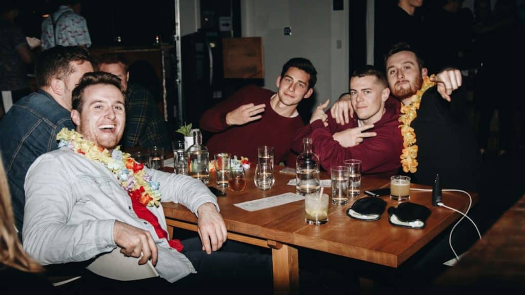 A group of men sitting around a wooden table.