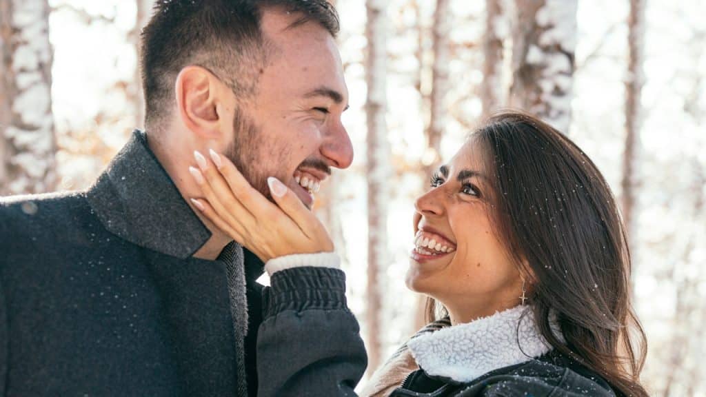 A man and a woman standing in snow.