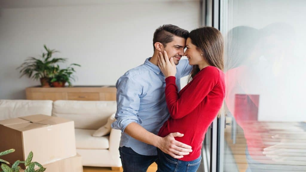 A couple hugging by the window