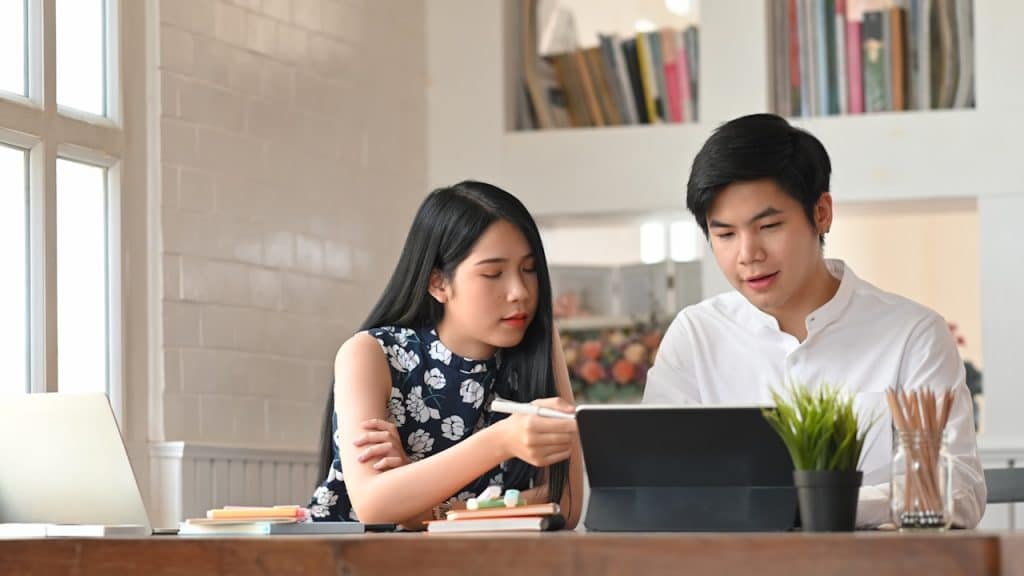 A couple working on a laptop together.