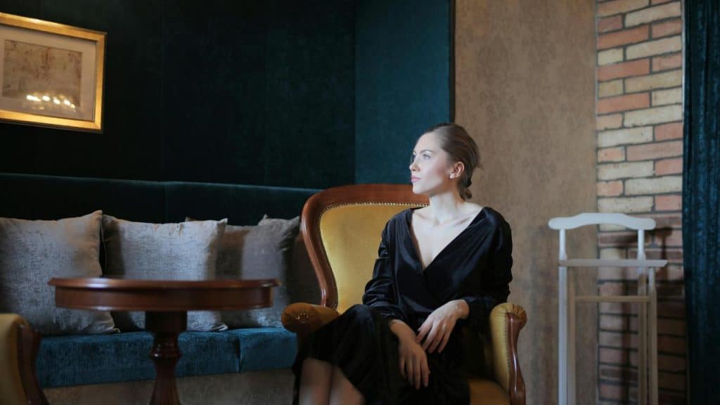 A woman sitting in an elegant chair looking to the side.