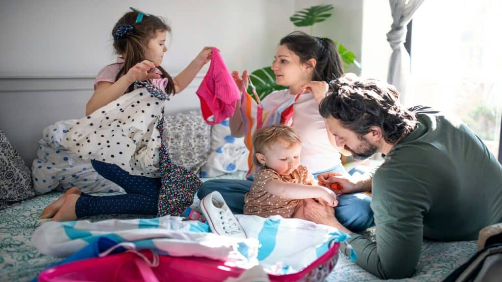 Parents trying to fold laundry with their kids