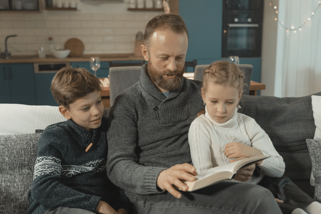 A Father Reading a Book to His Kids