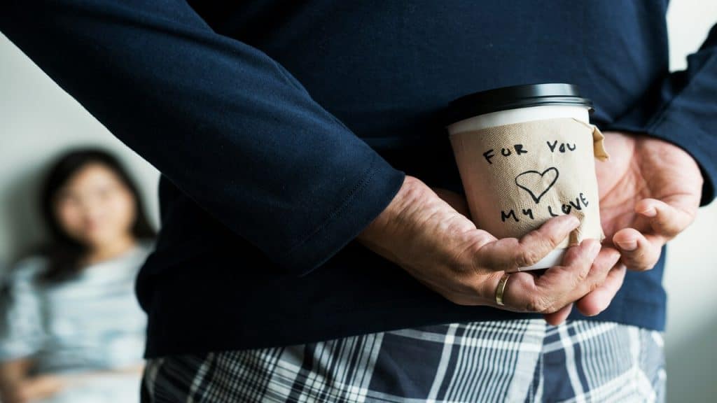 A man giving his wife a coffee