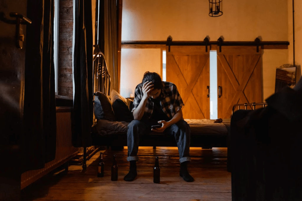 Man in Blue Denim Jeans Sitting on a bed