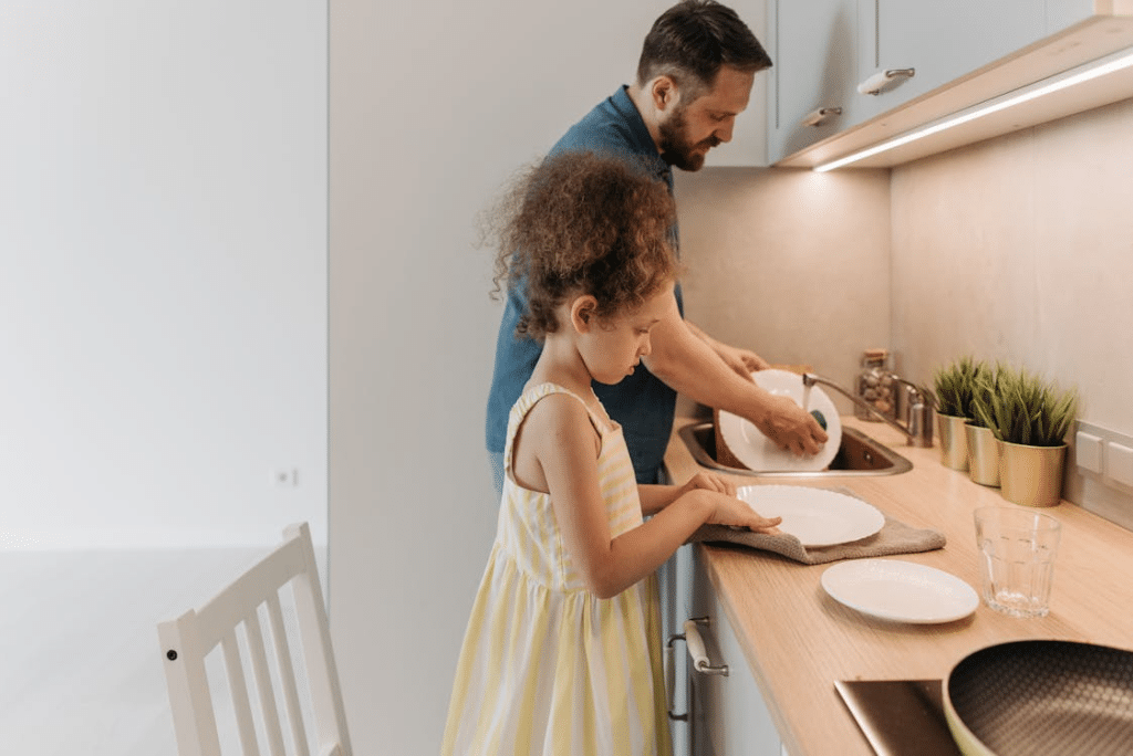 A Man Washing the Dishes with His Daughter