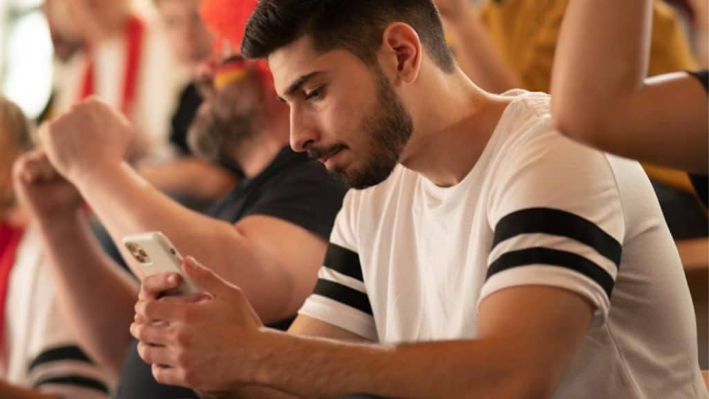 Man looking uneasy at multiple texts from his partner checking in