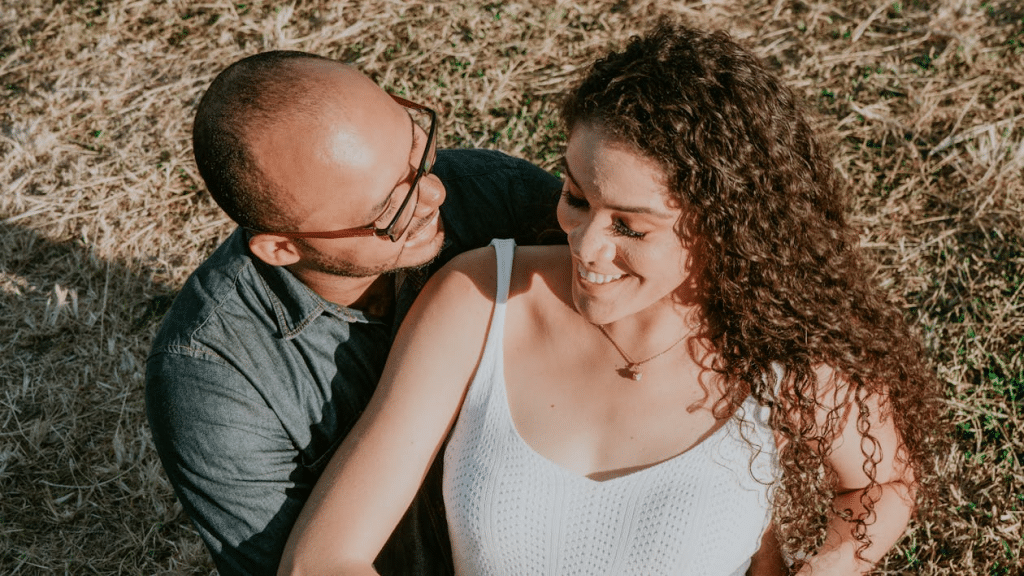 Man and Woman sitting on Grass Smiling