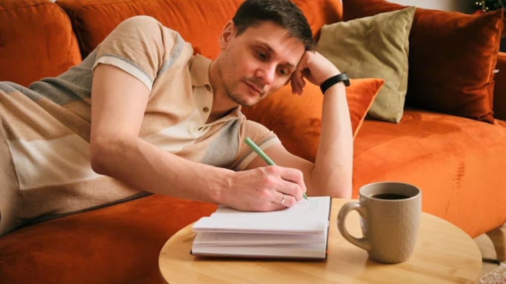 Man writing daily goals in a journal