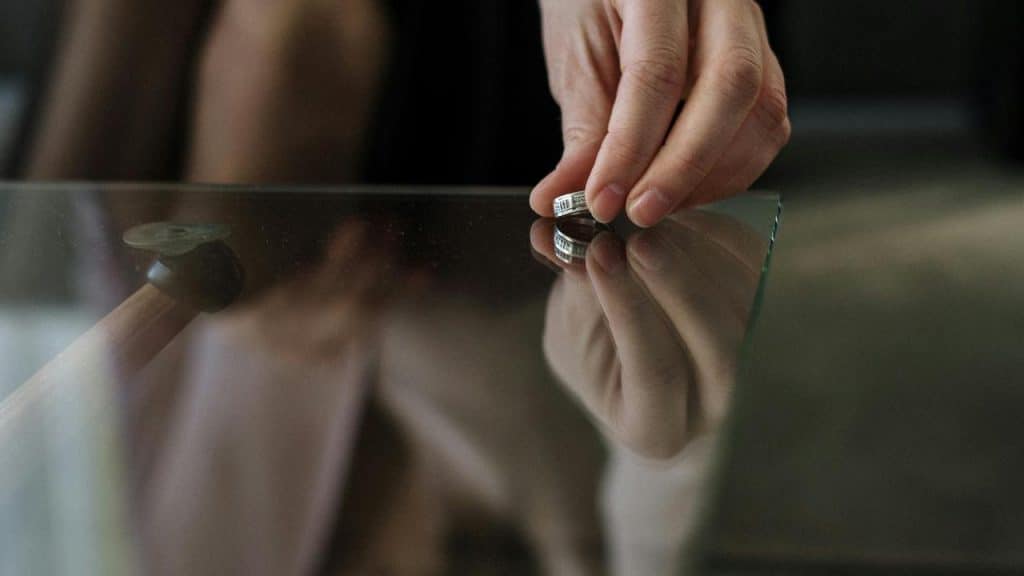 A person hand placing a silver ring