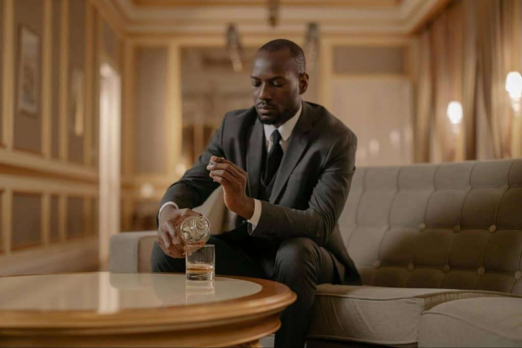 A man pouring whiskey on glass