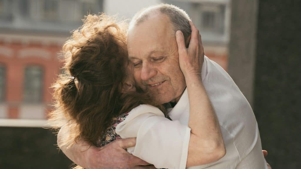 An older couple hugging each other. 