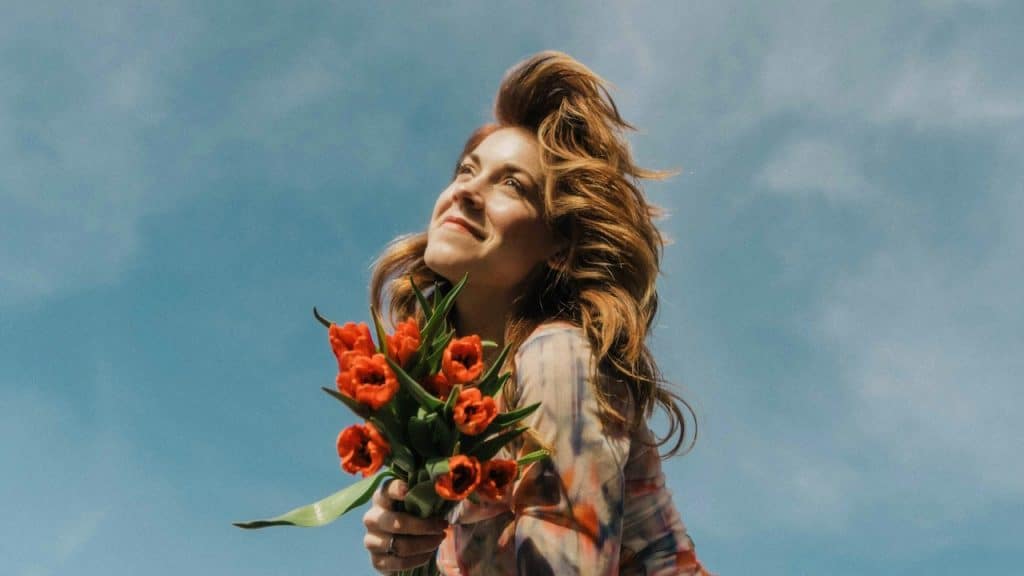 A woman holding flowers and smiling.