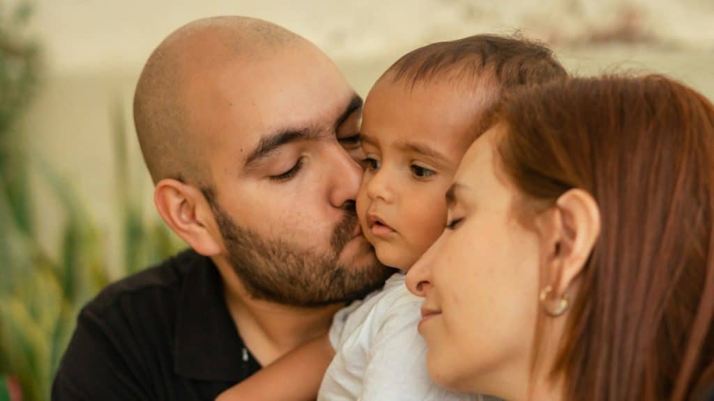 A man and woman holding a small child.