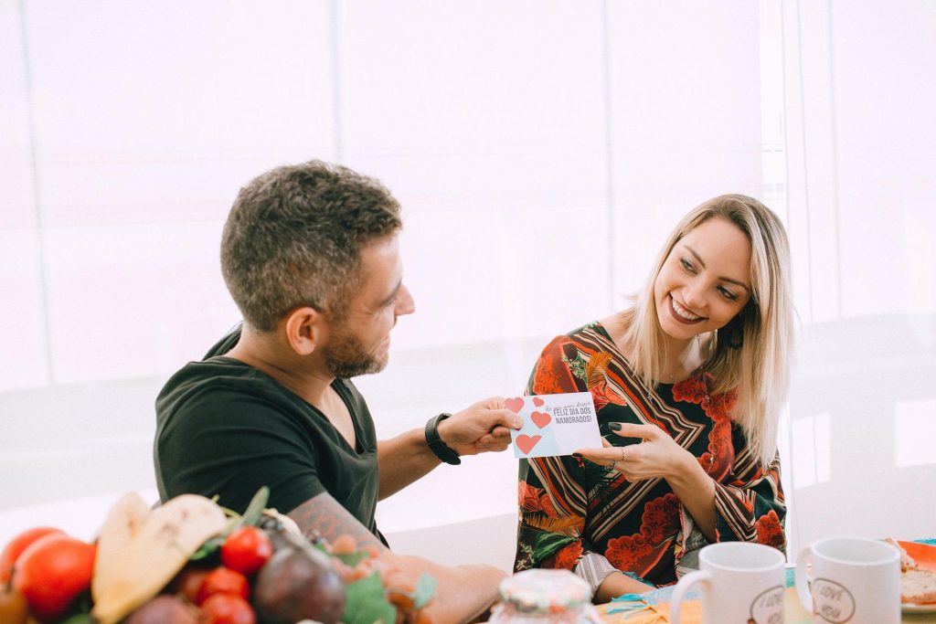 A man is giving a card to the woman.