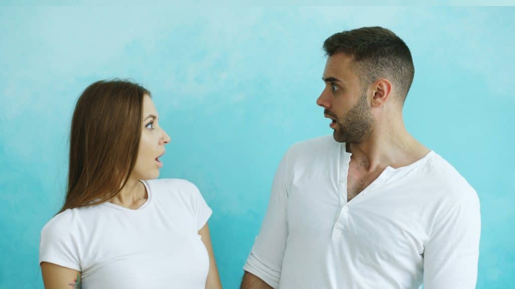 A Couple looking at each other with surprise.