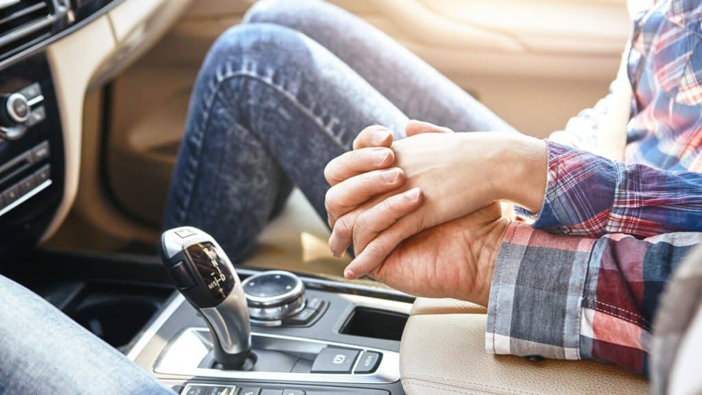 A couple holding hands in the car