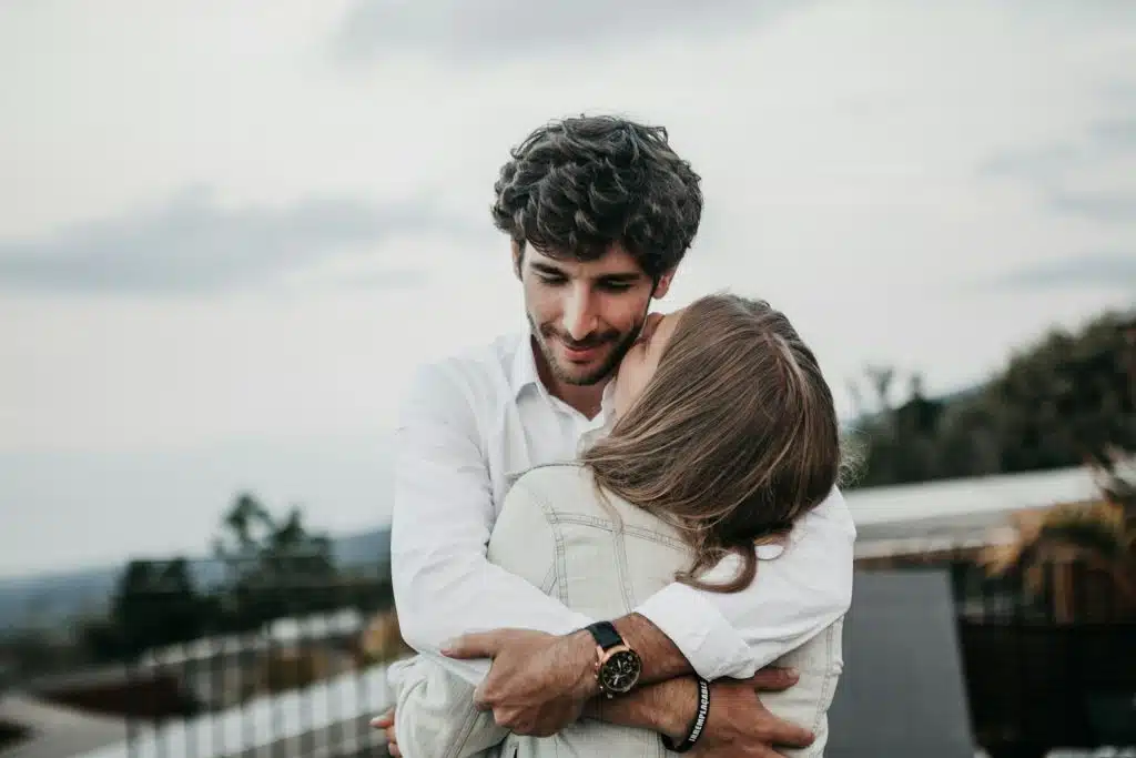 The man is hugging the woman.