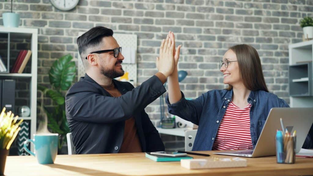 A couple high fiving at work