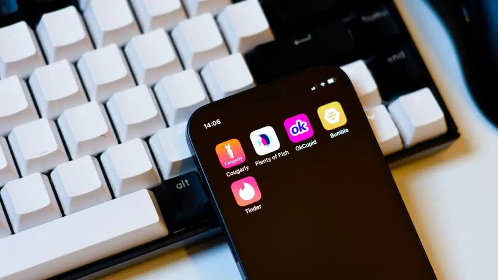 A smartphone showing dating app icons on a keyboard.