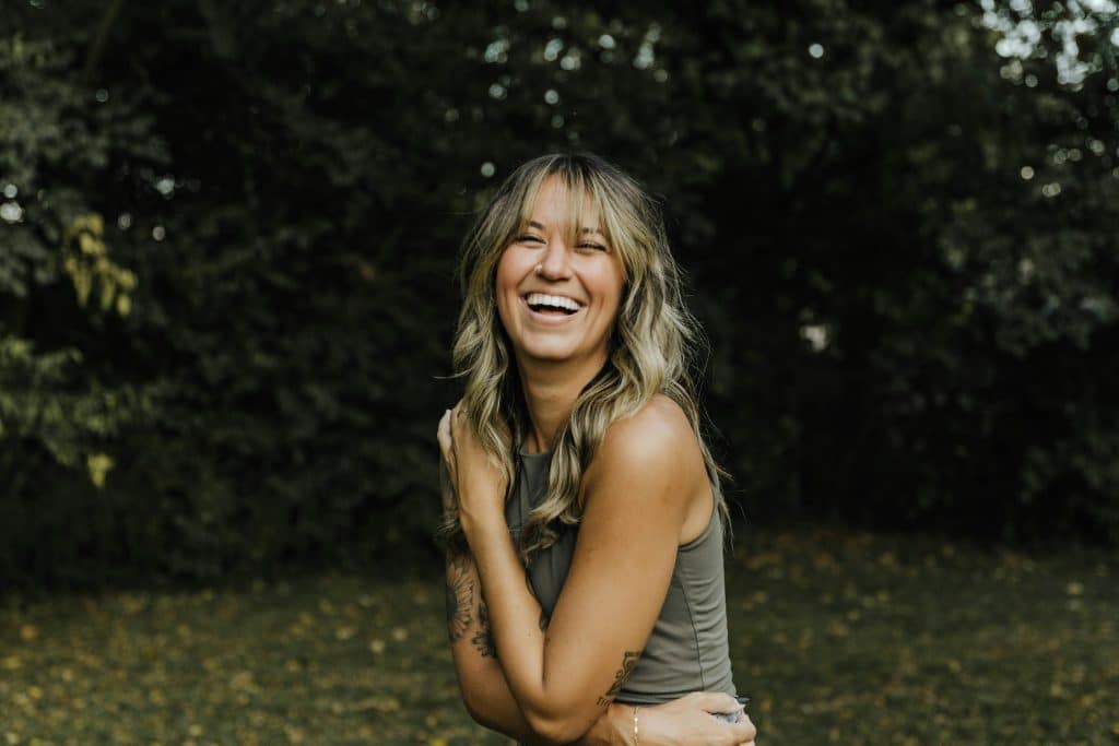 The woman is smiling while spending time outdoors.