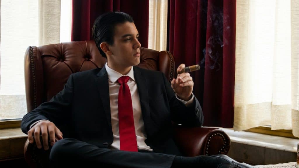 A man sitting in a chair smoking a cigarette.