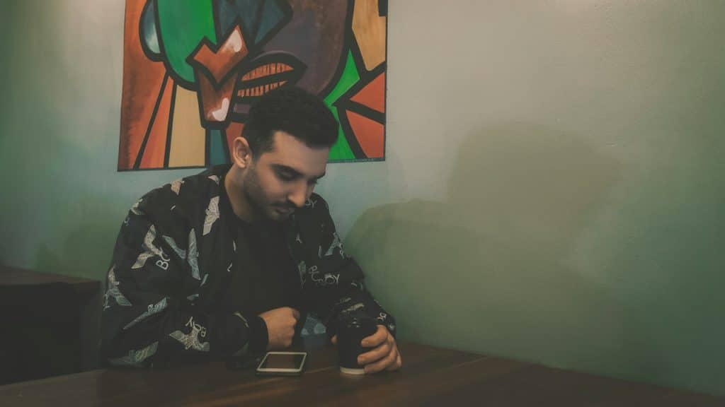 A man sitting at a table enjoying coffee.